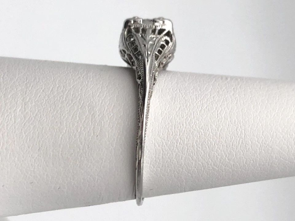 18K WHITE GOLD FILIGREE STYLE RING WITH SOLITAIRE 0.35CT DIAMOND SIZE: 6 2.1G: 18K WHITE GOLD FILIGREE STYLE RING WITH SOLITAIRE 0.35CT DIAMOND SIZE: 6 18k White Gold Filigree style Ring with center 0.35ct Diamond Condition: Used, has been cleaned Material: 18k White Gold Ring S