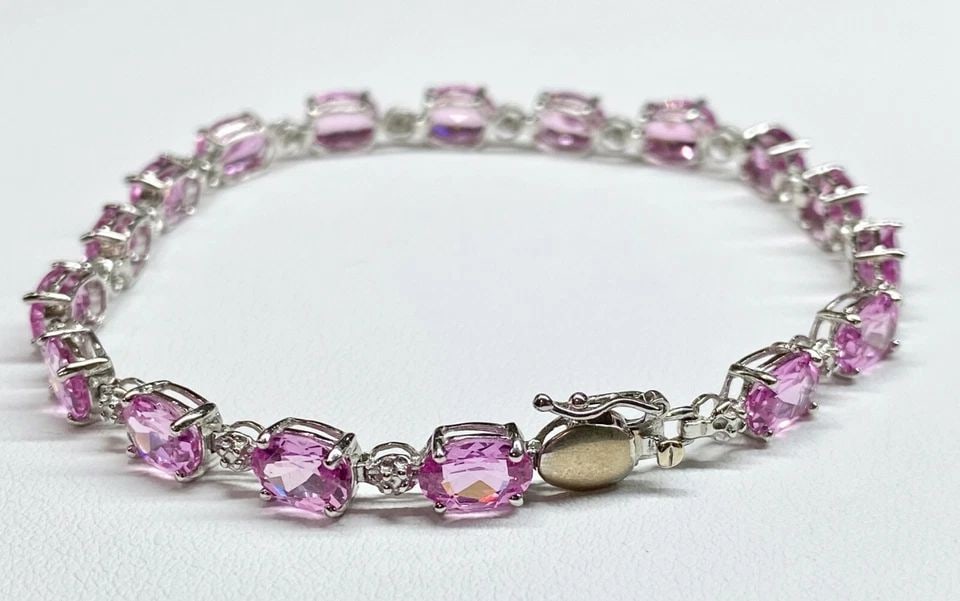 10K WHITE GOLD BRACELET, 0.08CTS OF DIAMONDS AND PINK C.Z. (7 INCH) 8.5 GRAMS: 10k White Gold Bracelet, 0.08cts of Diamonds and Pink C.Z. You are bidding on a pre-owned Women's 10k White Gold Bracelet with Diamonds and Pink Stones. The bracelet has minor scuffs and scratches fro