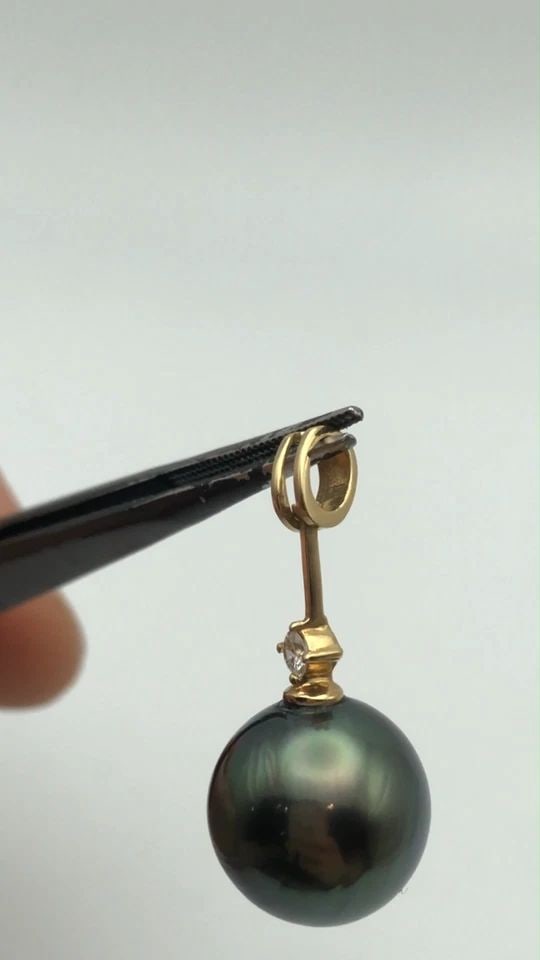 18K GOLD PENDANT WITH 13MM PEARL AND 0.08CTS OF DIAMONDS (4 GRAMS): 18K GOLD PENDANT WITH 13MM PEARL AND 0.08CTS OF DIAMONDS 4 GRAMS 18k Gold Pendant with 13mm Pearl and 0.08cts of Diamonds Condition: Used Material: 18k Yellow Gold Pendant Size: 29mm x 13mm Total Weig