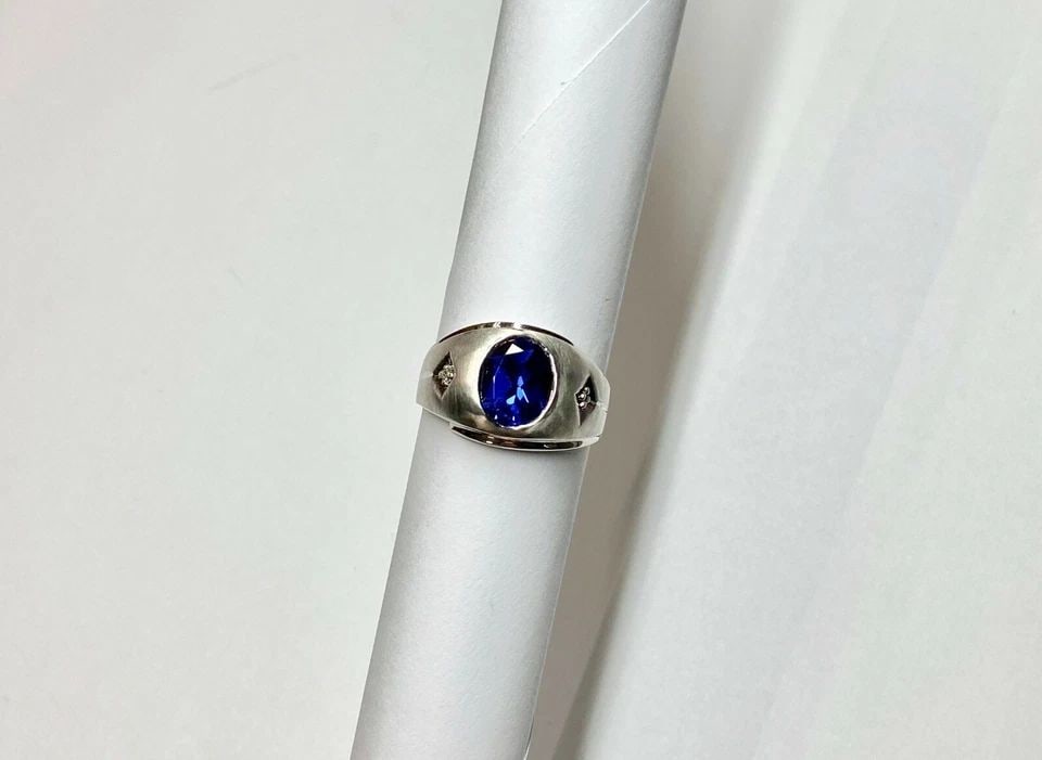 10K WHITE GOLD RING WITH SYNTHETIC SAPPHIRE AND 0.03CT DIAMONDS (SIZE 9.5) 8.1G: MEN'S 10K WHITE GOLD RING WITH SYNTHETIC SAPPHIRE AND 0.03CT DIAMONDS (SIZE 9.5) Men's 10k White Gold Ring with Synthetic Sapphire and 0.03CT Diamonds (Size 9.5) You are bidding on a pre-owned Men's 1