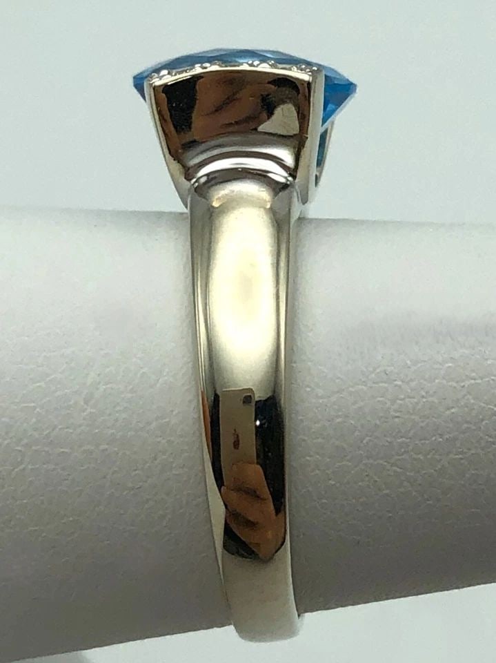14K WHITE GOLD RING WITH BLUE TOPAZ AND 0.06CTW DIAMONDS (SIZE 7) 5.9G: 14K WHITE GOLD RING SET WITH BLUE TOPAZ AND 0.06CTS OF DIAMONDS SIZE: 7 14k White Gold Ring set with Blue Topaz and 0.06cts of Diamonds Condition: Used Material: 14k White Gold Ring Size: 7 Weight: 5.