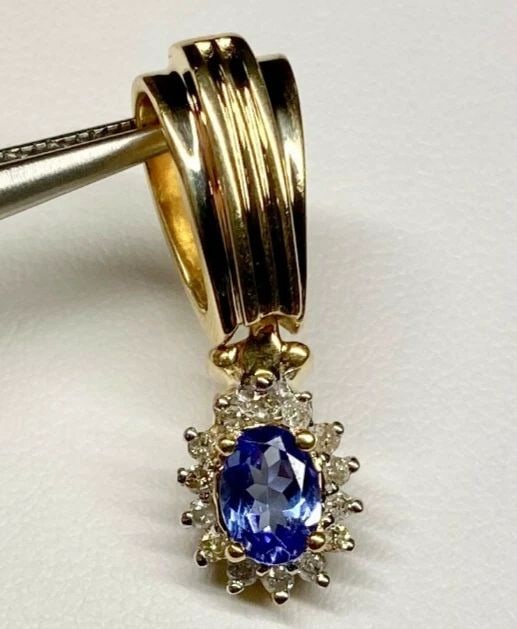 14K GOLD PENDANT WITH 7X5MM TANZANITE AND 0.20CTW DIAMONDS 5.1 GRAM: 14k Gold Pendant with 7mm x 5mm Tanzanite and 0.20cts of Diamonds You are bidding on a pre-owned Women's 14k Yellow Gold Pendant with 7x5mm Oval Faceted Tanzanite and Diamonds. The pendant has minor s