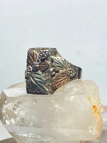 LEAVES DETAILED WITH OVERLAY METALS OVER STERLING SILVER MEN: LEAVES DETAILED WITH OVERLAY METALS OVER STERLING SILVER MEN Leaves detailed with overlay metals over sterling silver men Size 10 Weight 11.8g Length 3/4" Width 1/2" Thinnest part of band 3/16"