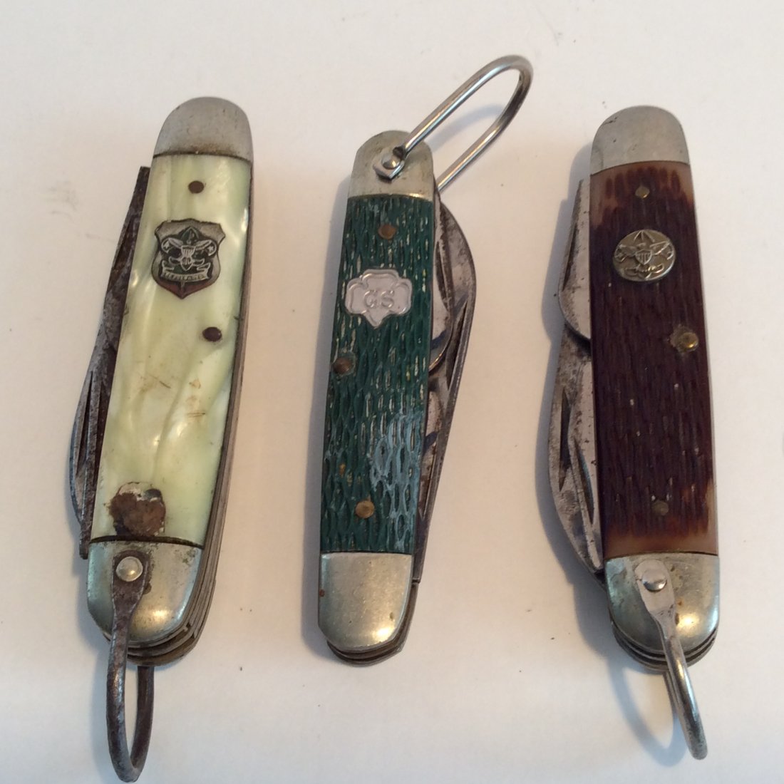 2 Boy Scouts knifes and 1 girls scouts knife: #1 yellow plastic handle boys scouts knife 3.75" no maker #2 Brown horn handle boys scouts knife 3.75 Ulster USA #3 green horn girls scouts knife 3.25" master USA