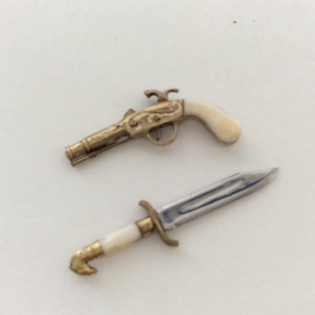 Antique 14k Miniature Percussion Pistol and Dagger: Antique miniature 14k gold pistol with bone handles articulated trigger and hammer moves Hallmarked Plus a 14k gold and Sterling dagger with bone Handel Pistol .80" just short of 1" by .5" Dagger just