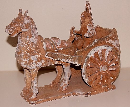 Northern Wei Carriage and a Rider: Origin: China. Circa: 386-534 A.D. Style: Nothern Wei Dynasty. Medium: Terracotta. H: 10" by W: 14". Man on a carriage pulled by a horse. Described as "part of an era of political turbulence and inten