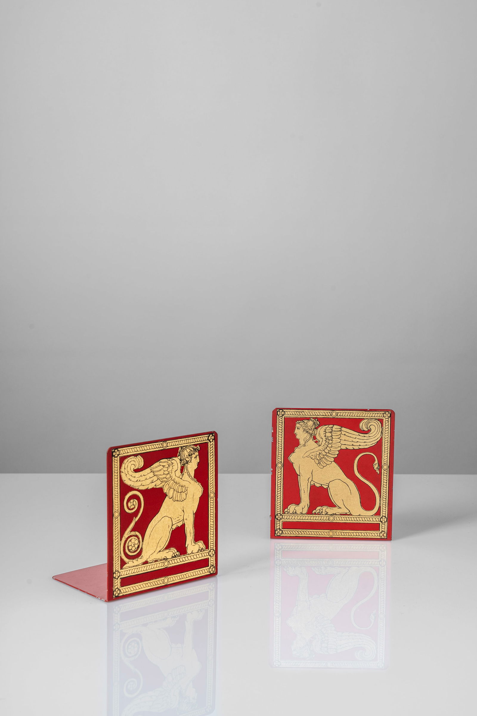 Piero Fornasetti (Milano 10/11/1913 - Milano 09/10/1988) - Pair of bookends, 'sphinx' decoration ,: 15 x 10 x 13,5 cm Pair of bookends with silk-screen 'right sphinx and left sphinx' printed decorationdeisgned in 1960 circametal screen printed, clothoriginal logo FORNASETTI - MILANO / MADE IN ITALY