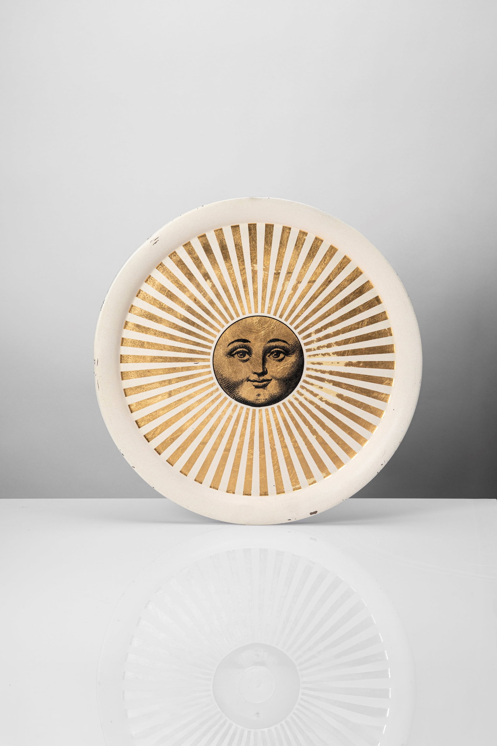 Piero Fornasetti (Milano 10/11/1913 - Milano 09/10/1988) - Tray with 'Sole raggiante' decor, 1950: 3 x 55,5 x 55,5 cm designed in 1950 circaexecuted nel 2000 circascreen printing and gold leaf on metallogo printed FORNASETTI MILANO on the frontFornasetti edition, Milan, Italy PROVENANCE Private