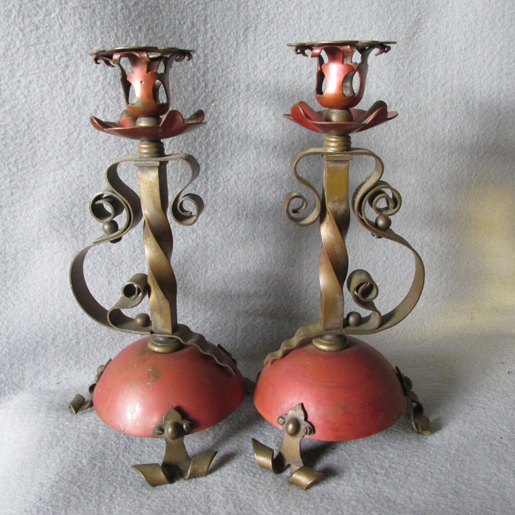 Pair Antique Gothic Strap Work Candlesticks: A pair of antique Gothic Strap Work Candlesticks. The Candlesticks each stand 9 3/8" high x 4 1/4" in diamter at the base. The pair are in good condition. There is some wear to the red bronze finish m