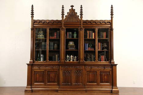 1870 Gothic English Library Bookcase or Display Cabinet: Hand carved about 1870 in the Gothic manner, this monumental English bookcase or display cabinet is solid walnut. Showing remarkable artistry, "linen fold" panels, crenelated towers and arched tracery