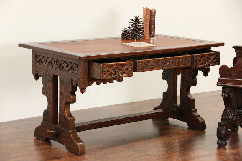 Oak Gothic Carved 1920's Library Desk w Leather Top: Hand carved in the 1920's to look like a Medieval Gothic antique, this solid oak library writing desk is from Scandinavia. Carefully "worn and distressed" to achieve the look of centuries, the finish