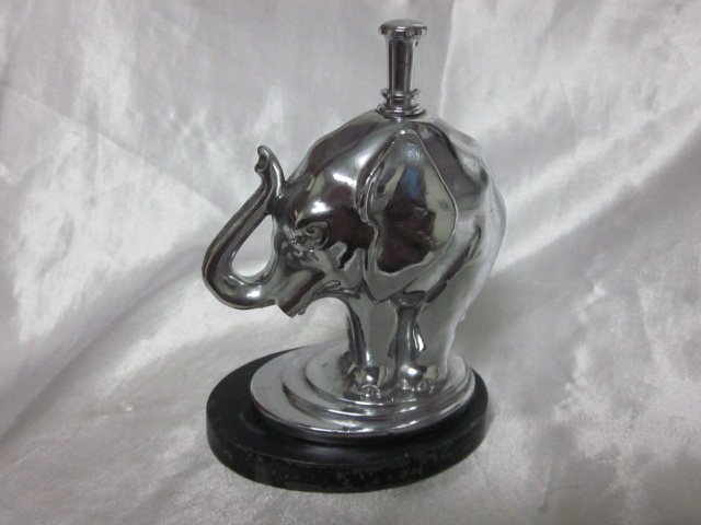 Ronson “Elephant” Petrol Striker Table Lighter © 1930’s: An Elephant on an oval gunmetal base with Chromium Plated Finish. Measures 5” High. To light, pull out wand on top of elephant’s back and strike along the trunk.