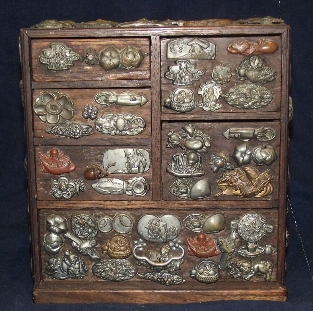 Japanese Antique Samurai Sword Menuki Box: Antique wooden box adorned with over 125 samurai sword, soft metal menuki. Measures 4” x 9” x 8.5”. Please note that this lot has a reserve. If you submit a maximum absentee bid, the bid will no