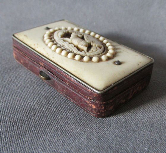 Antique 19thC European Antler Match Safe Vesta with: An antique Match Safe or Vesta. The Match Safe is European in origin, probably German. It features a hand carved antler or bone top with a pierced Stag or Deer design. The sides are leather on metal a
