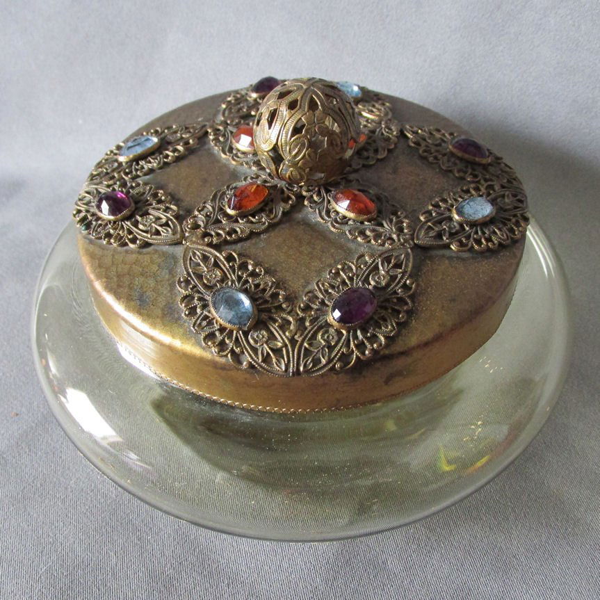 c1930s Jeweled Powder Jar with Filigree & Faceted: An antique Art Deco Powder Jar. The jar features a jeweled lid which is set with multi color glass stones, the base is a pale amber glass. The jar is large with overall dimensions of 6" in diameter x
