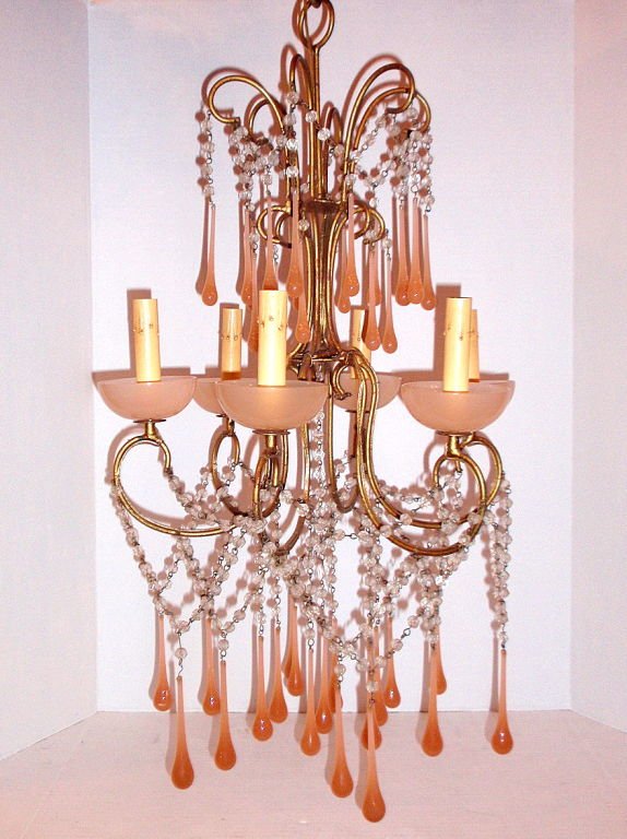 GILT METAL CHANDELIER WITH PEACH GLASS: An Italian gilt metal and crystal chandelier with pale pink opaline glass colored glass hanging and bobeches. Rewired. Measurements: Height: 34? (drop) Diameter: 17? This item ships from New York, NY
