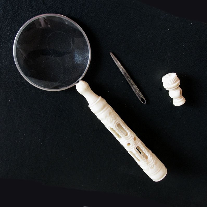 Antique Magnifier with Needle case Handle, Sewing: An antique desk or sewing magnifing glass. The magnifier has a hand carved bone handle with a Needle case and has a large cut steel needle. Overall dimensions are 5 5/8" long and the glass is 1 3/4" i