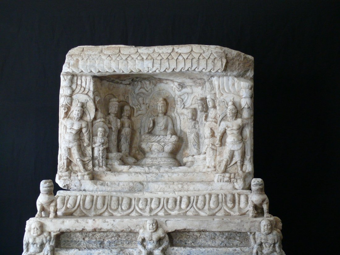 Marble Niche on an Ornamental Base with Guardian Lions: The niche with an assembly of Buddhist figures is carved from a block of micaceous marble. It is placed on an elaborately carved square base, also made of the same material. The form is unusual and ca