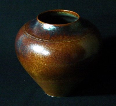 Paul Jeselskis: This striking gold, Southwest vase exhibits burnished accents around the rim. 9-1/4" diam x 8-3/4" h. It is signed on the bottom. Paul Jeselskis: "My glaze technique is based upon layering one glaze o