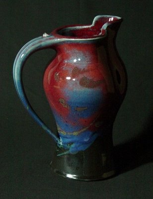 Paul Jeselskis: This beautifully decorated red and blue pitcher is of perfect proportions. 4-1/2" diam (6" with handle) x 8-1/2" h. It is signed on the bottom. Paul Jeselskis: "My glaze technique is based upon layeri