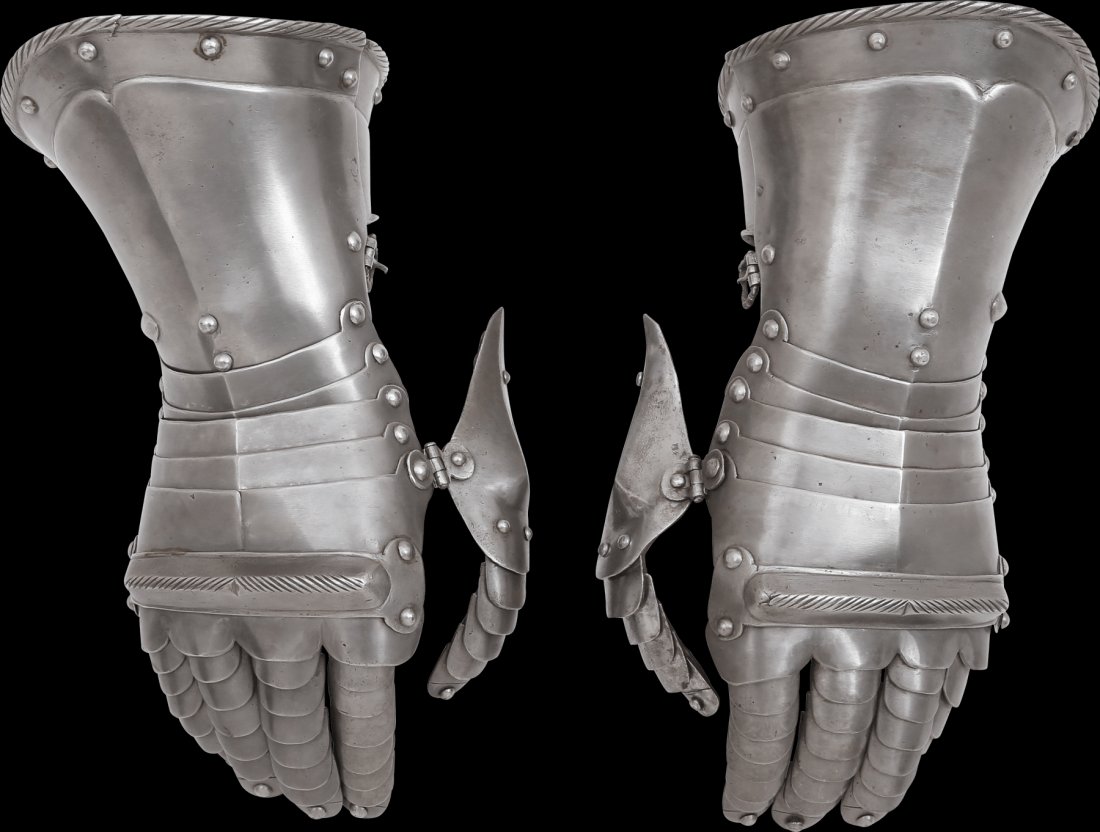 A FINE PAIR OF GERMAN GAUNTLETS C.1560-80: Iron, with rolled and roped edge flared cuffs with sunk borders, five metacarpal plates and raised knuckle plates. Pivoting hinged thumbs. Articulated fingers and thumbs, the terminal plates with fing