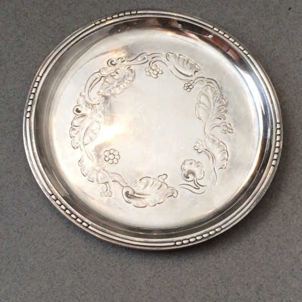 Georg Jensen Sterling Silver Wine Coaster by Harald: Georg Jensen sterling silver wine coaster with grapevine and foliate motif, designed by Harald Nielsen. Excellent condition. Dimensions: 4.5"L Shipping Domestic: Shipping rates are determind by destin