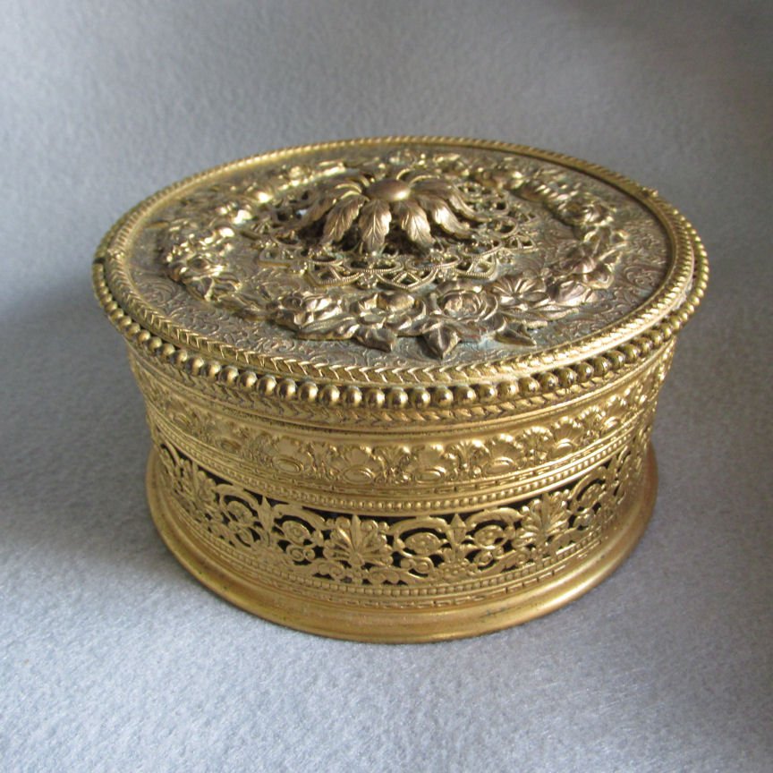 Antique Art Deco Powder Jar by Apollo: An antique Art Deco Powder Jar. The Powder Jar is made of filigree metal and has the original glass liner, it is signed "APOLLO". Overall dimensions are 5" in diameter x 2" high. Shipping Domestic: Sh