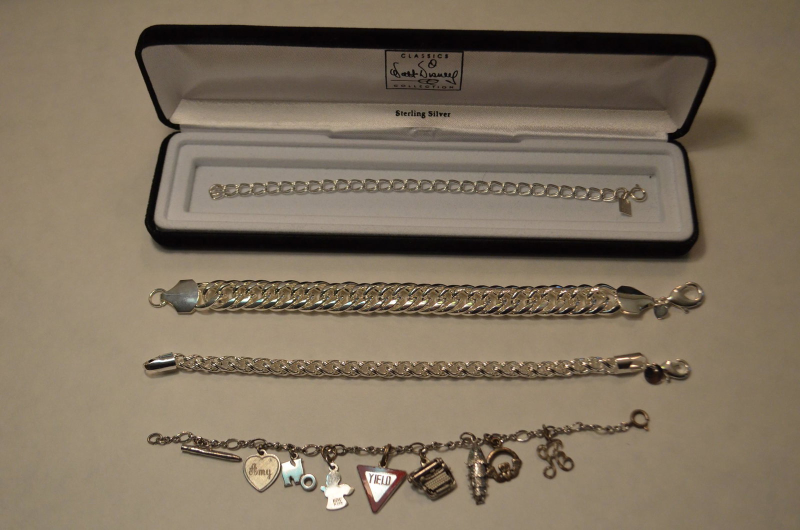 4 Sterling Bracelets: 4 Sterling bracelets. (1) 7.5" long charm bracelet with 8 charms. (1) 8.5" long heavy link bracelet. (1) 8" long round link bracelet. (1) 7" long Classic Walt Disney Collection bracelet. 2.74 troy oz.