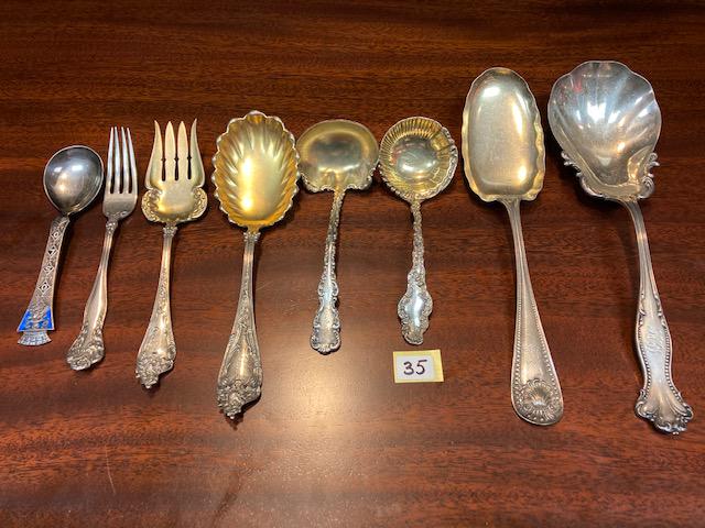 Eight Sterling Silver Pieces of Flatware: Eight sterling silver pieces of flatware from various manufacturers. (3) gold wash serving pieces, (2) large serving spoons, (1) gold wash serving fork, (1) dinner fork and (1) miscellaneous spoon. To