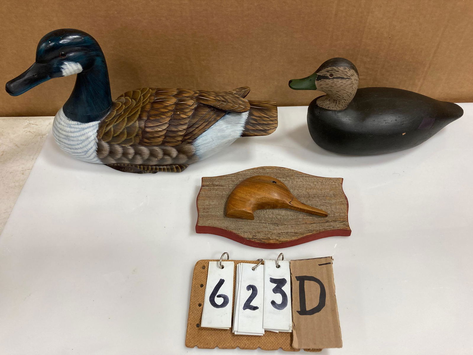 Three Hand Carved Wood Duck Decoys: Three hand carved and hand painted wood duck decoys. Includes one black duck, one Canada goose and one unpainted decoy head, mounted. From the collection of one family in St. Lawrence County, NY who l