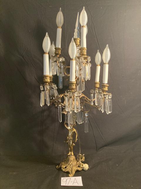 Brass Ten Arm Fancy Candelabra: 1890-1920 brass ten arm fancy candelabra with figure on the base and prisms. 31.5"h x 16"w. Please read the Terms and Conditions of this auction thoroughly for IMPORTANT bidder information.
