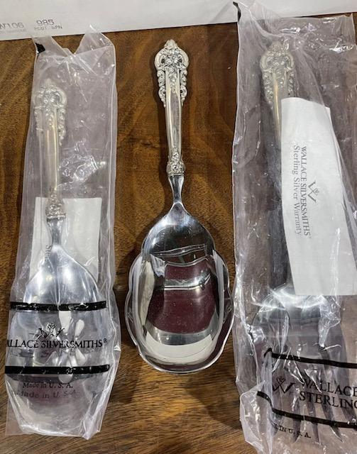 Three New Wallace Grand Baroque Sterling Serving Pieces: Three new Wallace Grand Baroque sterling silver serving pieces. One fork in box, 11.125"l x 2.375"w. One slotted spoon in box, 9.875"l x 2.75"w. One scalloped edge spoon, 9.625"l x 2.75"w. Please read