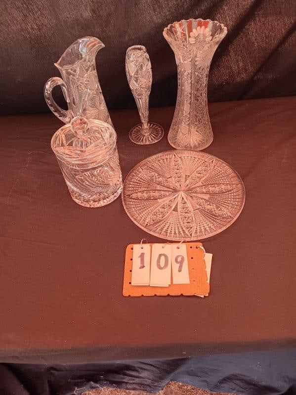 Five Hand Cut Glass Pieces: Five hand cut glass pieces. One 1890's Victorian period water pitcher, 7"l x 4"w x 11"h. One 1890's Victorian vase with starburst design, 4.25"l x 10.125"h. One Victorian sunflower vase, possibly Cana