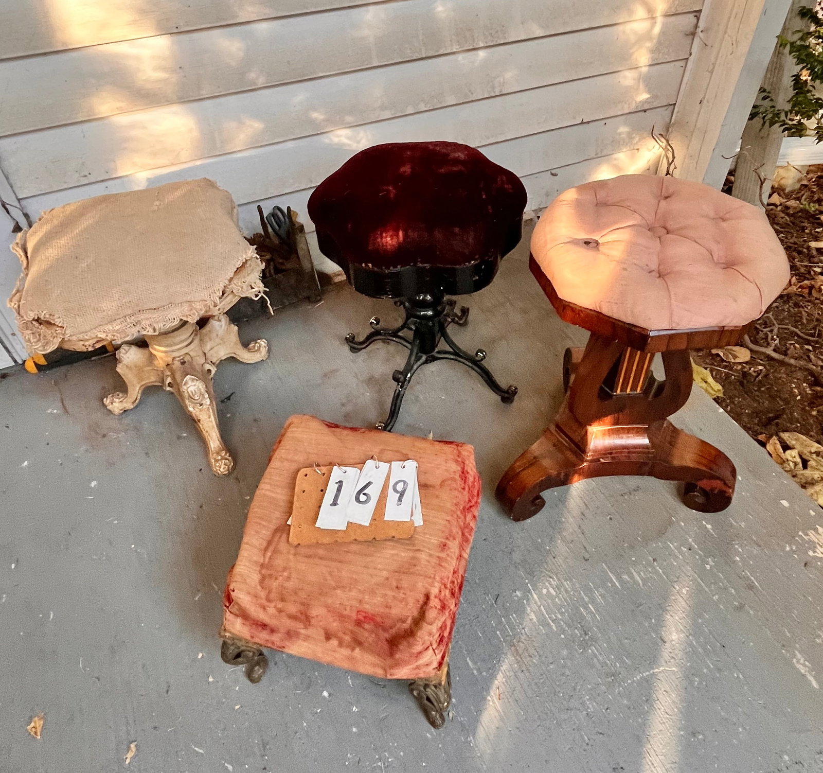 Four 19c Antique Foot Stools: Four 19th century antique foot stools. One 1890s upholstered organ foot stool with female head on cast iron feet. Upholstery needs work. One 1860 rosewood upholstered organ foot stool. Has some veneer