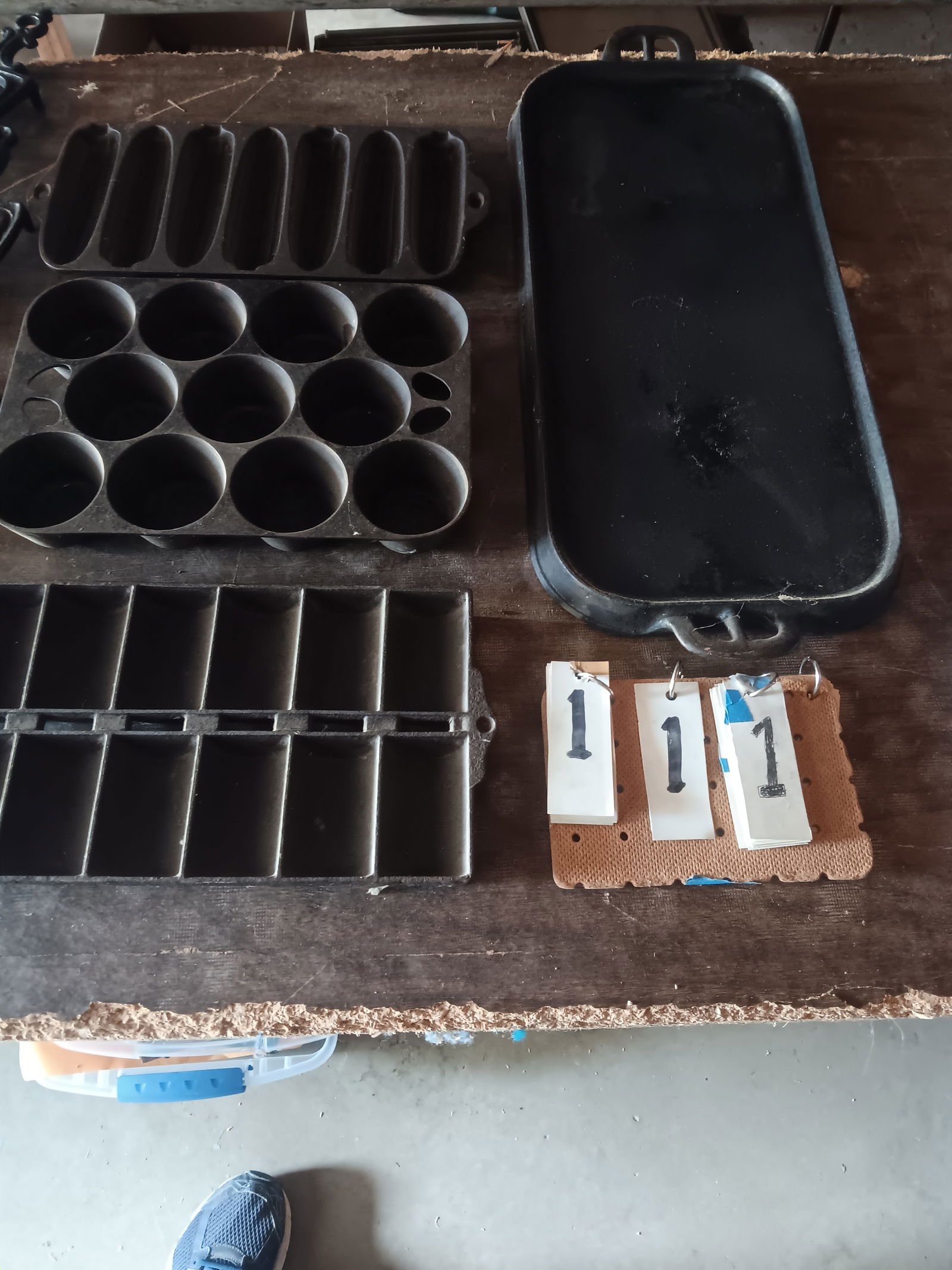 12 Pieces of Vintage American Cast Iron: 12 pieces of vintage American cast iron. One #8 Griswold griddle, USA. One #7 griddle. One corn mold. Two muffin molds. Seven trivets. Please read the Terms and Conditions of this auction thoroughly f