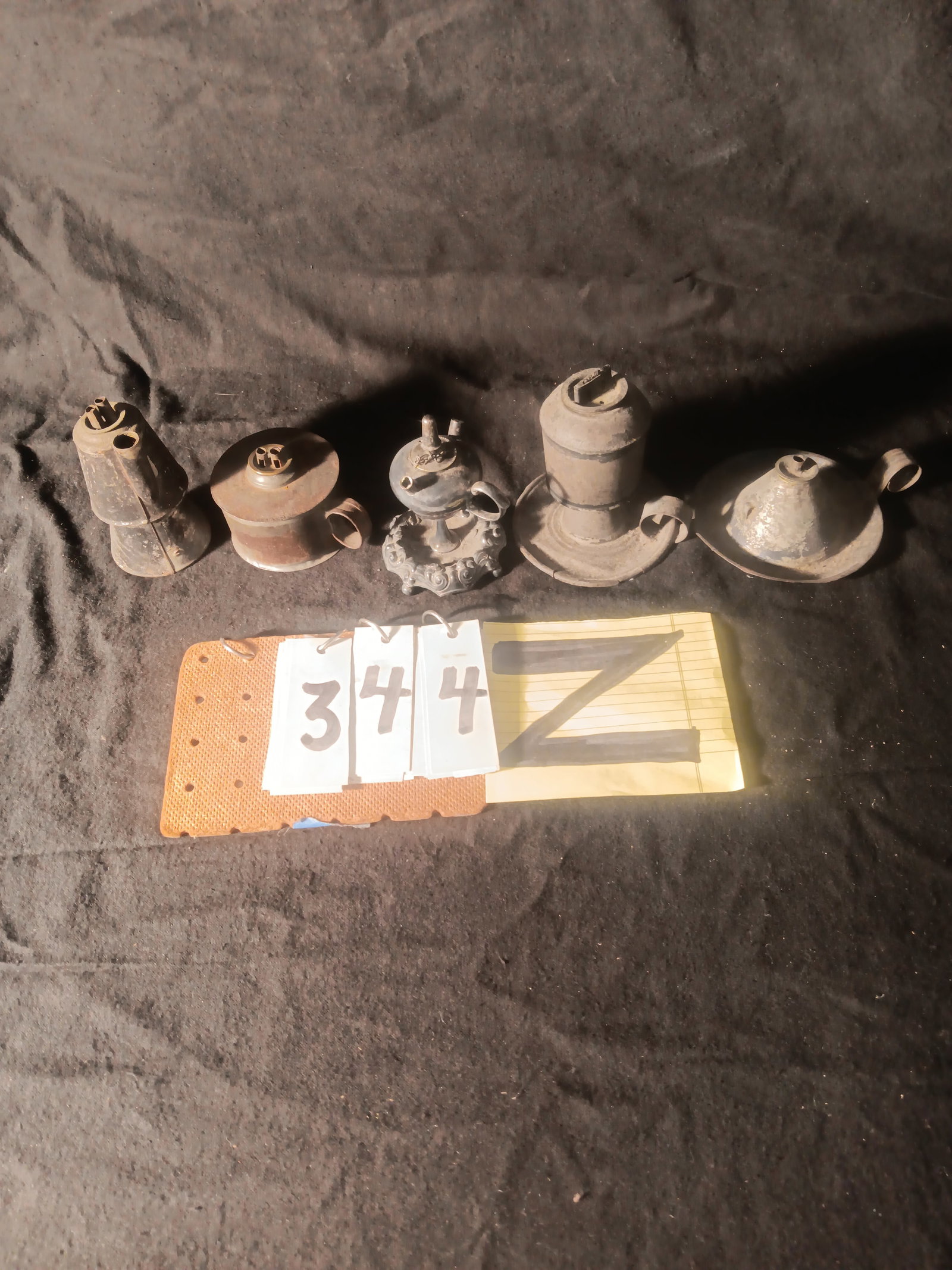 Five 19c Whale Oil Lamps: Five 19th century whale oil lamps. (Left to Right) One handmade tin whale oil lamp, 2.375" dia. x 4.5"h. One tin handmade whale oil lamp, 4" dia. x 2.75"h. One Terry & Co. silver plated whale oil lamp
