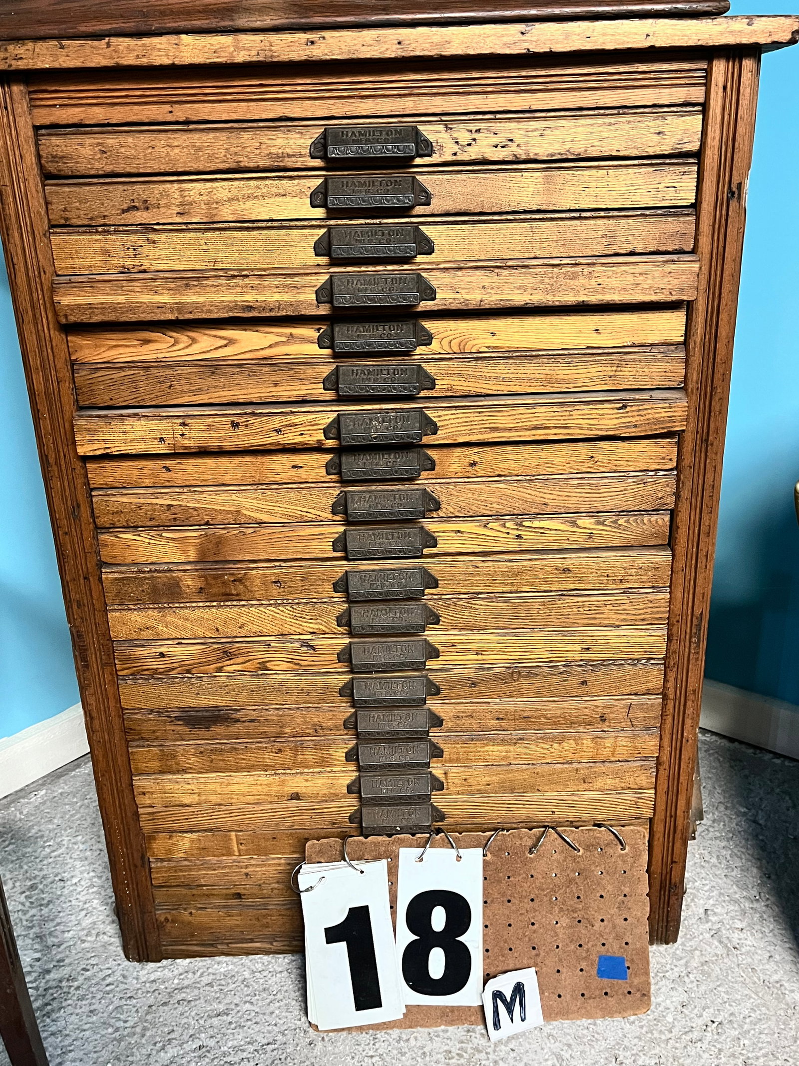 20 Drawer Cabinet by Hamilton Co.: 20 drawer cabinet by Hamilton Co. Possibly chestnut. 25.25"w x 22"d x 37.5"h. See photos. Please read the Terms and Conditions of this auction THOROUGHLY for IMPORTANT bidder information.