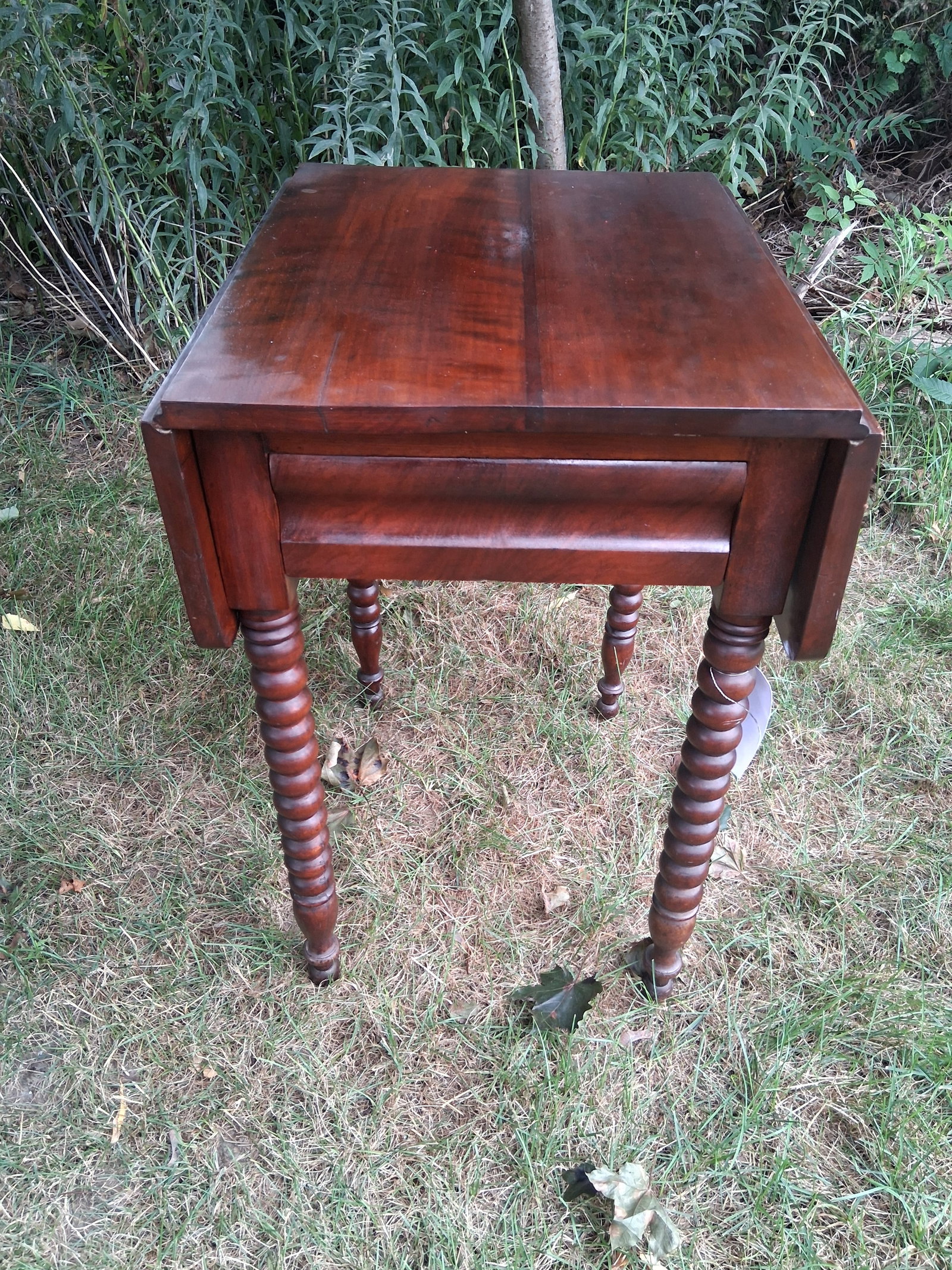 1860s American Spool Leg Mahogany Drop Leaf One Drawer Stand: 1860s American spool leg mahogany drop leaf one drawer stand. Closed it is 17"w x 23.75"d x 29.75"h. Open it is 33.5"w x 21.75"d x 29.75"h. See photos. Please read the Terms and Conditions of this