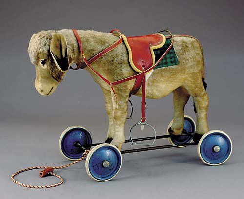 Steiff mohair ride-on donkey: Steiff mohair ride-on donkey circa 1930-50glass eyes, excelsior stuffing, shaved muzzle, black tipped ears and tail, leather tack and saddle, ear button, ring pull with EEY-OR sound, steel frame, rubb