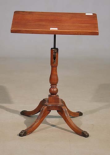 Sheraton style mahogany reading stand 20: Sheraton style mahogany reading stand 20th century slant top mounted on a mechanical adjustable baluster-form pedestal with platform base; raised on saber legs with brass paw feet. (Good condition, mi
