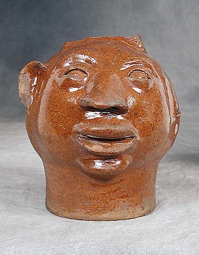 Folk art pottery face jug circa 1900 (Ch: Folk art pottery face jug circa 1900 (Chips to nose, ear and top of head; missing other ear) H7 1/2"