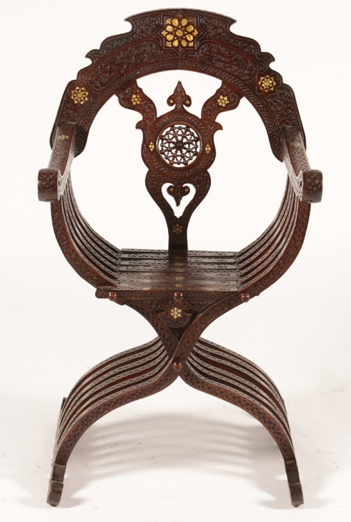 SYRIAN SAVONAROLA CHAIR RELIEF CARVED 1900: A good Syrian savonarola chair having overall relief carving with mother of pearl and ebonized wood inlaid decoration throughout circa 1900. Ht: 40.5" Wd: 23" Dpth: 23"