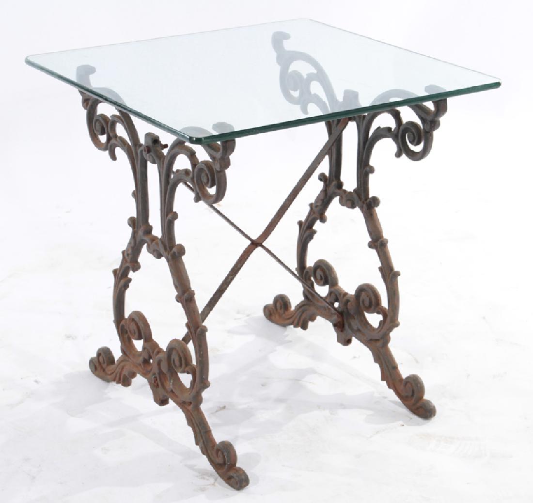 CAST IRON GARDEN TABLE LYRE FORM SIDES 1940: A cast iron garden table with glass top having stylized lyre form sides with scroll decoration circa 1940. Ht: 25.5" Wd: 24" Dpth: 26"