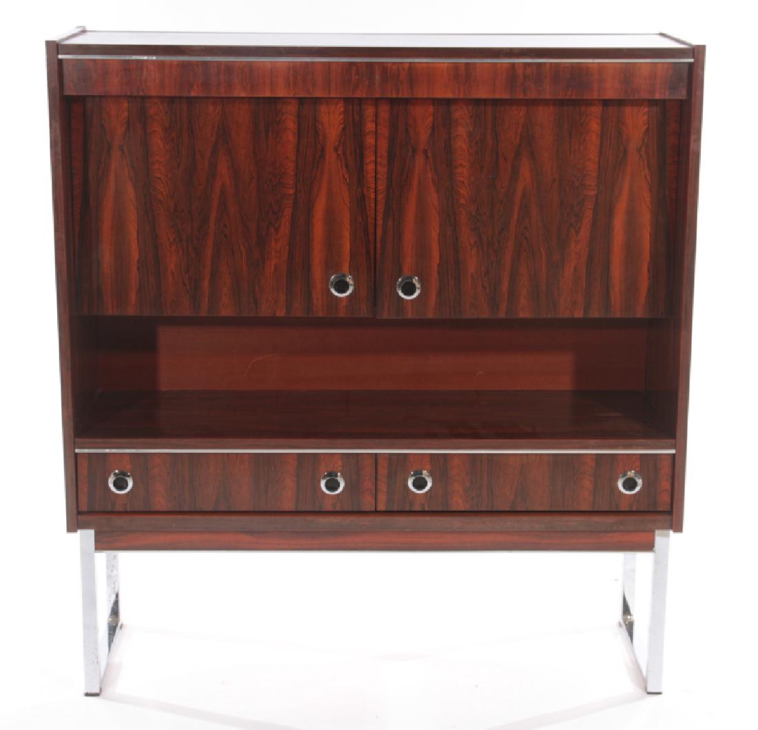 ROSEWOOD AND CHROME CREDENZA ON CHROME BASE: A rosewood and chrome credenza having two recessed doors over an open shelf above two drawers all raised on chrome base. Ht: 50.5" Wd: 47.5" Dpth: 15.5"