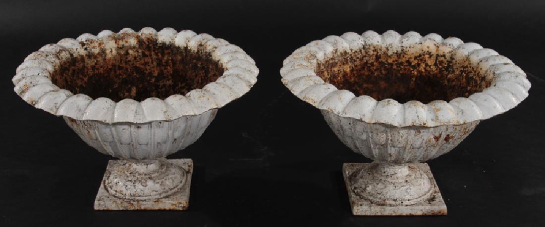 PAIR CAST IRON GARDEN URNS: A pair of cast iron garden urns having stylized egg and dart rim and figural and foliate decorated socle. Ht: 11.5" Dia: 19"