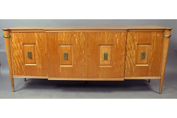 A grand scale Andre Arbus style sideboard with: A grand scale Andre Arbus style sideboard with stepped front and four doors. Each with central panel and bronze pull, all supported on turned and tapered legs with bronze cap. Interior fitted with she