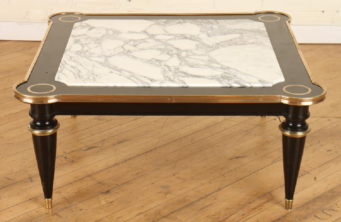 JANSEN EBONIZED WOOD MARBLE TOP COFFEE TABLE: A Jansen French ebonized wood marble top coffee table resting on tapered legs with bronze mounts circa 1940. Ht: 15" Wd: 32" Dpth: 33"