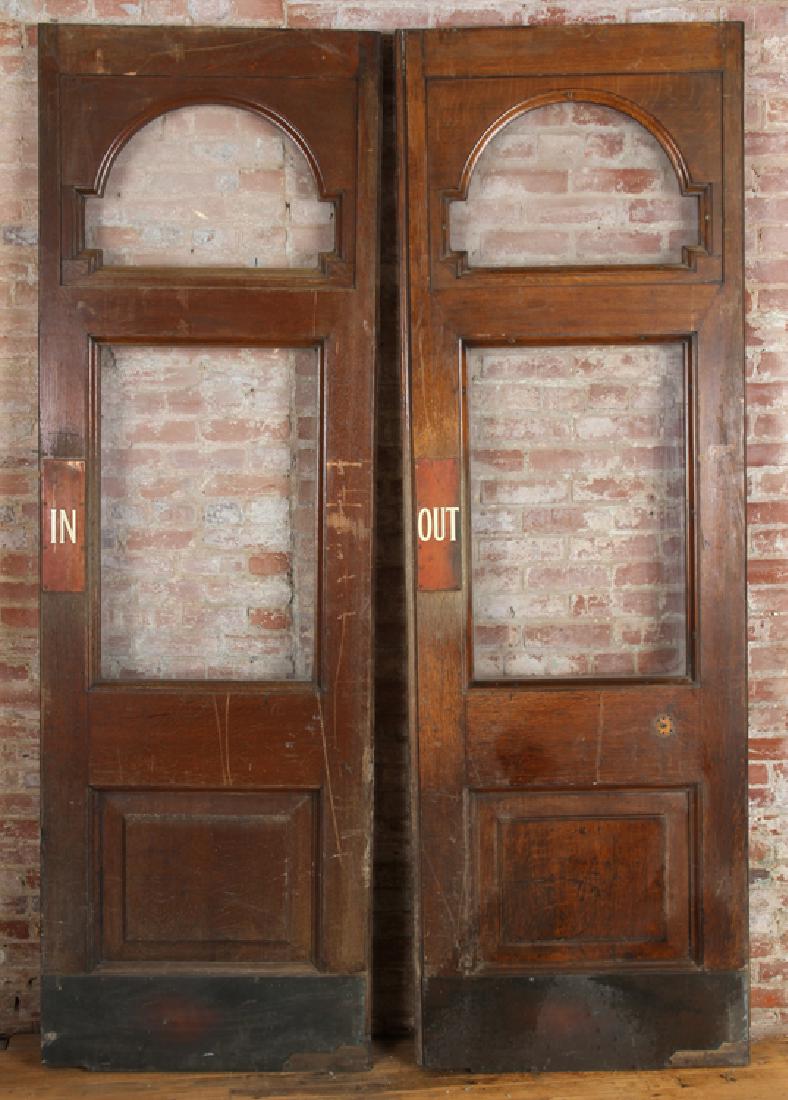 PAIR MONUMENTAL OAK DOORS WITH GLASS PANELS: A pair of monumental oak doors having two glass panels. Ht: 97" Wd: 28" Dpth: 2"