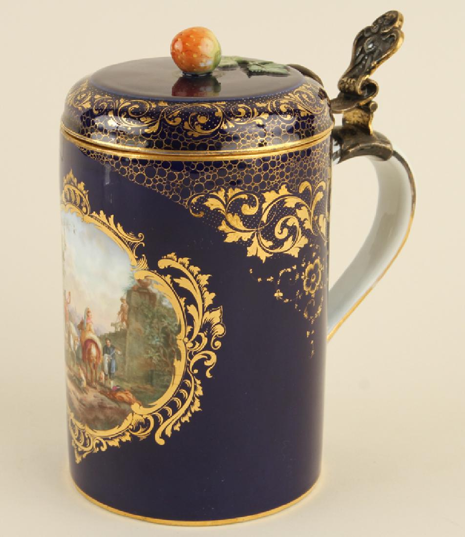 19TH C. MEISSEN GILT AND COBALT TANKARD MARKED: A nineteenth century Meissen gilt and cobalt tankard with cover. The panel depicting a stag hunting scene and inner cover having a view of Dresden. Cross swords mark in blue underglaze. Ht: 7.25" Dia: