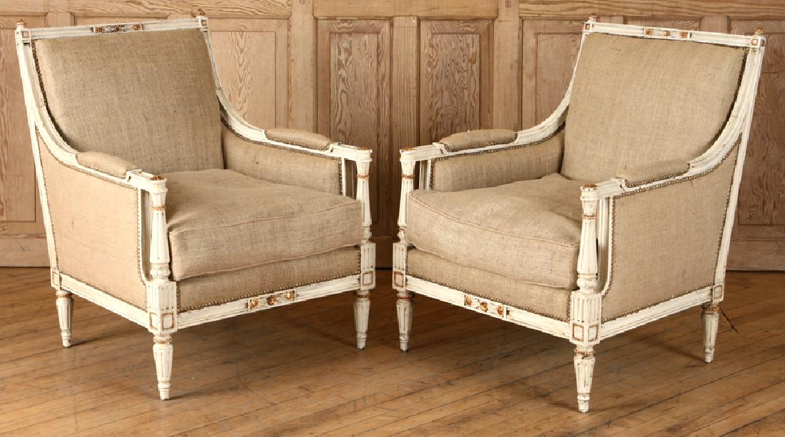 PAIR FRENCH BERGERE CHAIRS MANNER OF JANSEN: A pair of French painted and gilt Louis XVI style bergere chairs in the manner of Jansen. Recently reupholstered in burlap. Ht: 34" Wd: 27" Dpth: 29" Seat: 18"
